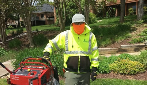 Level Green landscaping crew member sanitizing truck