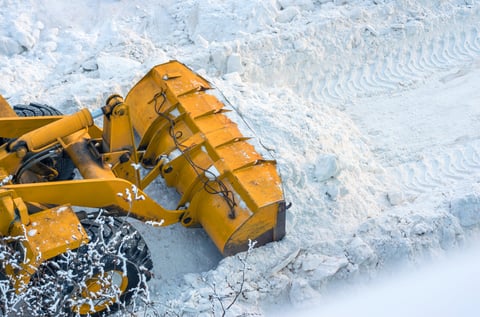 overhead photo of front loader pushing snow into pile