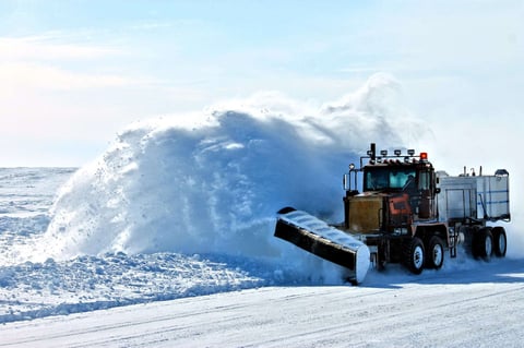 large truck removes snow on roadway